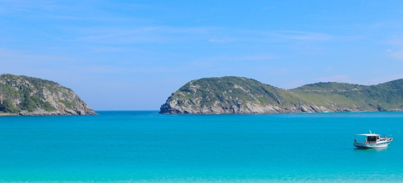 Mar azul entre ilhas e uma embarcação turística