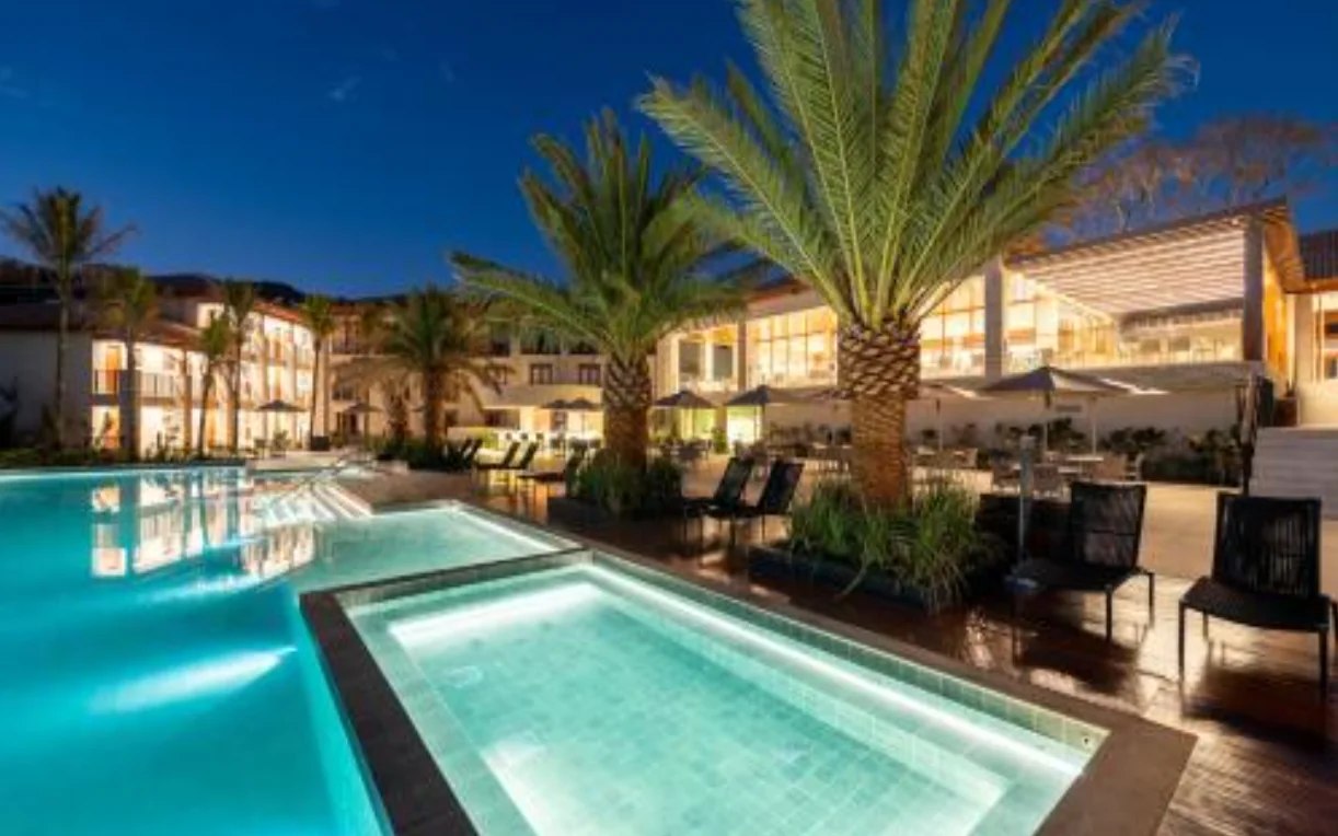 Piscina iluminada à noite no Pyreneus Residence Resort